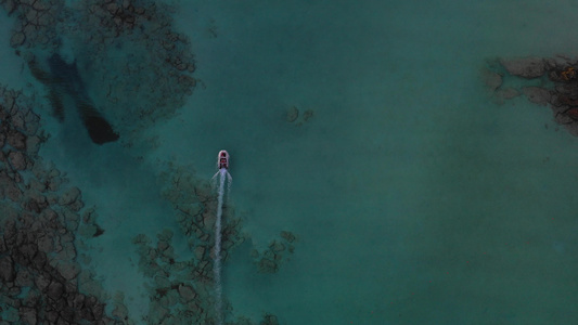 船在令人惊叹的水晶般清澈的海水上的空中俯视图空中无人机视频