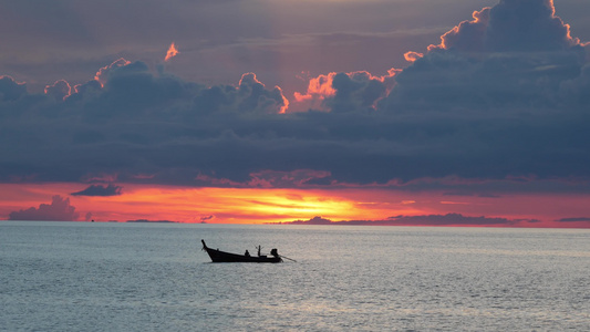 日落时在海中划船在多云的傍晚日落时分漂浮在平静海面视频