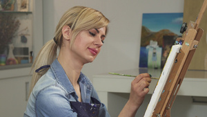 一位美丽的女艺术家在她的工作室微笑着绘画作品的特写9秒视频