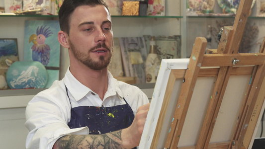 英俊的留胡子男艺术家在艺术工作室画画视频
