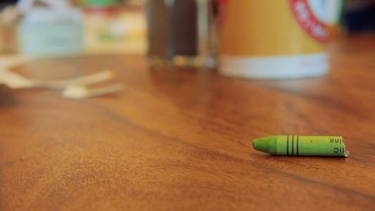 棕色木制桌子上的绿色面纸蜡笔卷视频