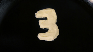 数字3形状的黄油在热锅上熔化60秒视频