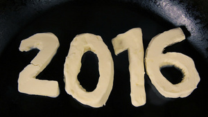 数字2016形状的黄油在热锅上熔化59秒视频