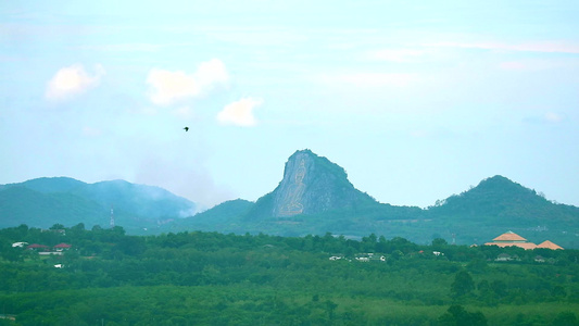 在悬崖和山地背景上飞回山丘和布达的鸟烟视频
