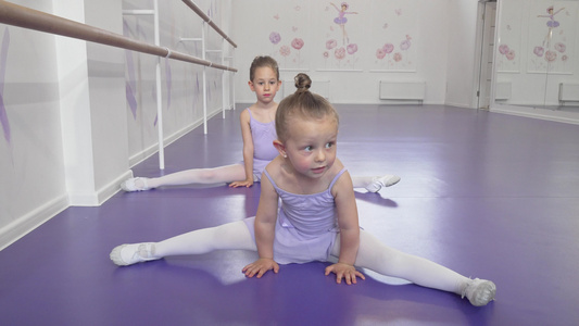 两个可爱的小芭蕾舞女孩在芭蕾课上伸展做分裂视频
