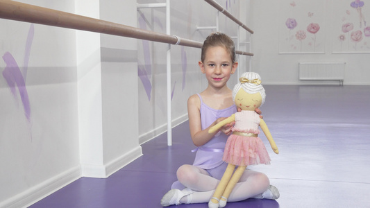 一个可爱的小芭蕾舞女挥舞在摄像机上用洋娃娃玩的镜头视频