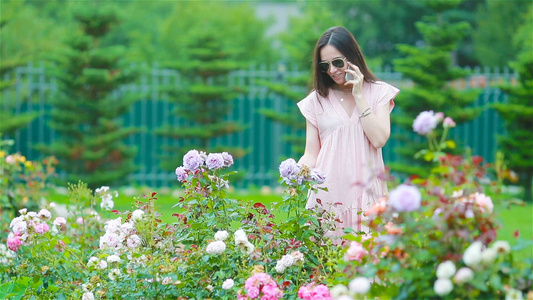 在花园的年轻女孩美丽的玫瑰中玫瑰的气味视频
