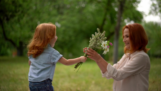 美丽的孩子送鲜花给微笑的母亲视频