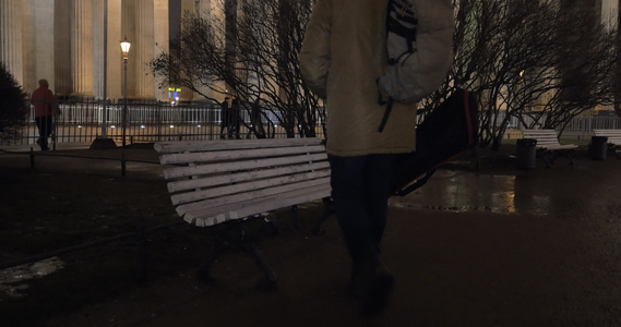 男子在晚上散步时坐在公园的长椅上视频