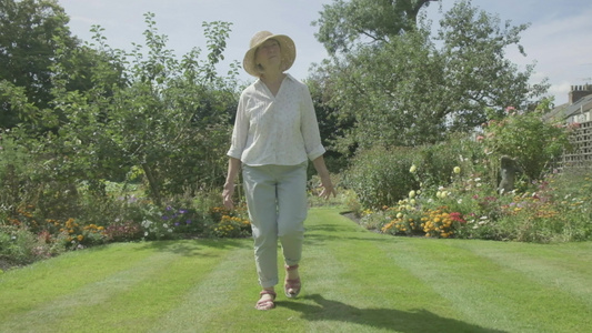 高级天主教女老人在花园里走过自己的花园视频