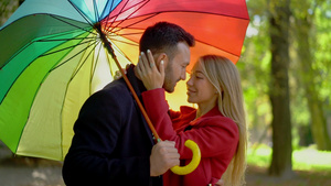 一对夫妇在彩虹伞下走在公园里11秒视频