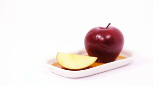 白色盘子上的红苹果和红苹果切片白底的蜂蜜被孤立9秒视频