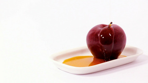 将蜂蜜倒在白盘的红苹果上24秒视频