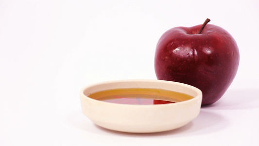 在白色背景中隔离的红苹果和一碗蜂蜜视频