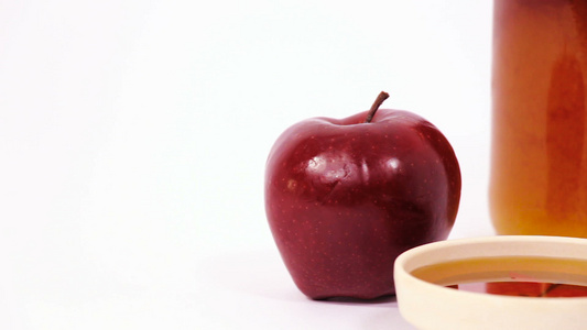 红色苹果和一罐蜂蜜和一碗蜂蜜在白色背景上被孤立视频