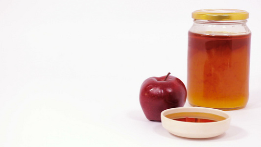 红色苹果和一罐蜂蜜和一碗蜂蜜在白色背景上被孤立视频