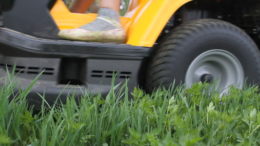 年轻女孩驾驶草坪搬运工割草视频