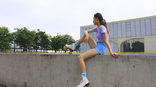 运动女孩穿着轮滑鞋坐着休息视频