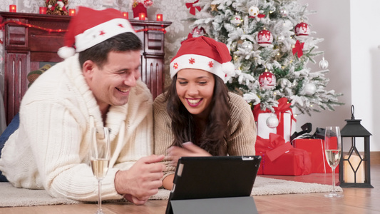 圣诞快乐的一对情侣在圣诞节装饰的房间在线订购礼物视频