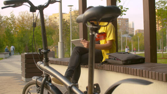 穿着黄色衬衫的男子在公园工作视频