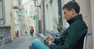 使用平板电脑坐在街上的成年男子在街上13秒视频