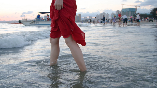 4K女孩在夕阳下的海水中行走视频