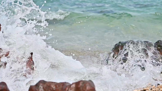 海南海岸线上的礁石白沙滩海浪慢动作视频