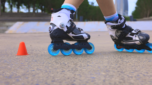 年轻女孩穿着单排轮滑鞋用障碍物练习花式轮滑视频