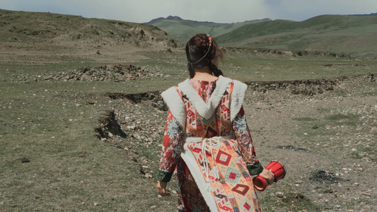 4K慢动作藏族女孩风中行走在高原视频