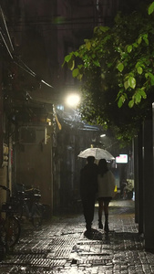 素材慢动作升格拍摄城市雨天夜晚路灯下回家的情侣背影回家的路视频