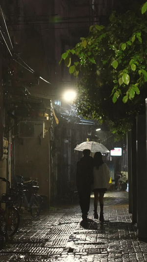 素材慢动作升格拍摄城市雨天夜晚路灯下回家的情侣背影回家的路61秒视频