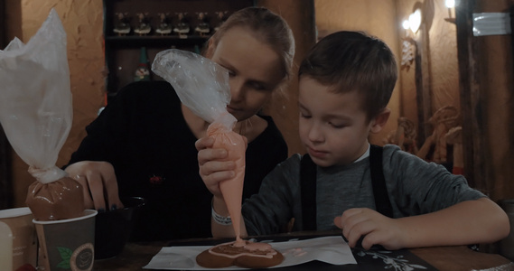 婴儿和母亲用冰淇淋装饰饼干视频
