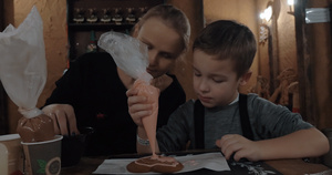 婴儿和母亲用冰淇淋装饰饼干10秒视频