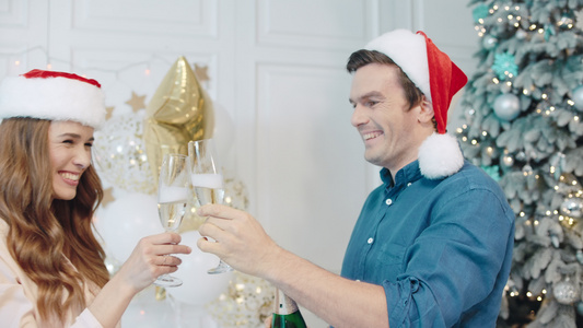 在圣诞树附近喝香槟的一对幸福情侣视频