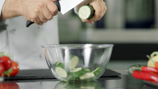 厨房的师在玻璃碗里 慢地在厨房里 切新鲜黄瓜视频