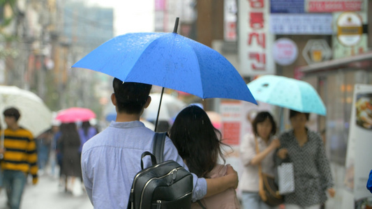 实拍韩国雨中情侣打伞行走视频视频