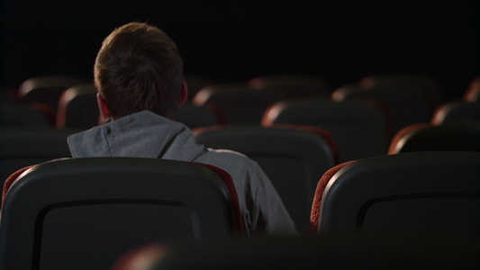 一名男子坐在空的电影厅视频
