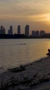 夕阳下在江边亲子玩水的人群素材视频