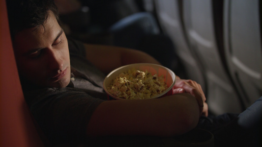 睡着男人在电影院吃爆米花盒视频