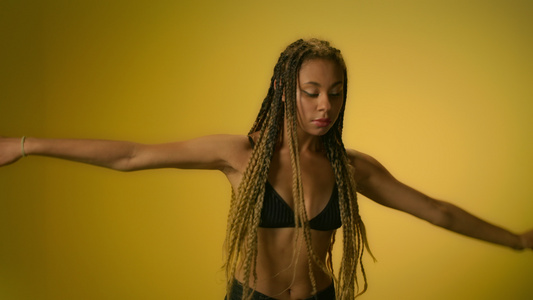 非洲裔美女性在黄色背景下慢动作跳舞[黑非洲]视频
