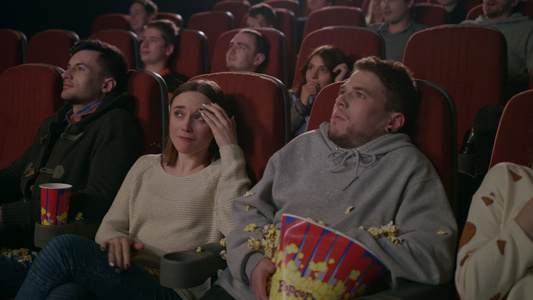 年轻人在电影院看恐怖时害怕视频