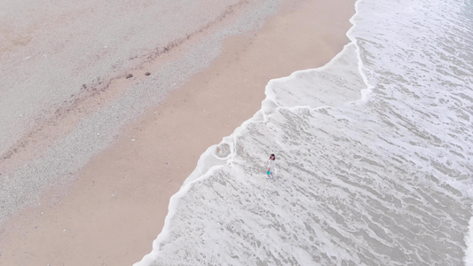 美丽的女人站在沙滩海浪里视频