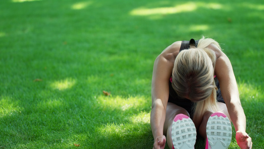 运动员妇女在夏季公园健身训练前做伸展运动视频