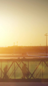 夕阳黄昏机场廊桥下飞机推着行李箱的旅客视频