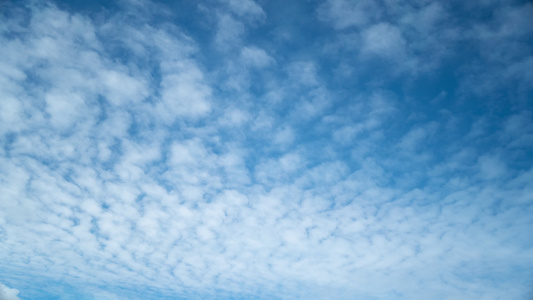 在蓝天空中不断从右向左循环的白色环状云云,无缝、无缝的圆形时间折叠视频