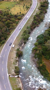 航拍山谷中蜿蜒的河流公路公路运输视频