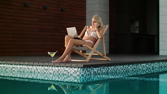 在游泳池边从事笔记本电脑工作的商业妇女视频