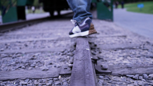 4k慢镜头升格拍摄4k素材火车铁轨上行走的少年脚步特写43秒视频