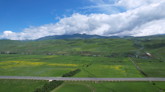 航拍新疆一望无际的高山草原和高速道路4k素材视频