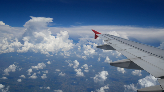 一架飞机在白云和蓝天上空飞行的机翼视频